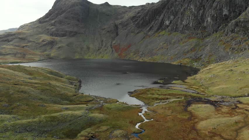 Aerial view of Stickle Tarn lake, located in the Lake District, Cumbria, UK. Popular tourist attractions in Great Langdale valley, famous for its glacial ribbon lakes and rugged mountains.