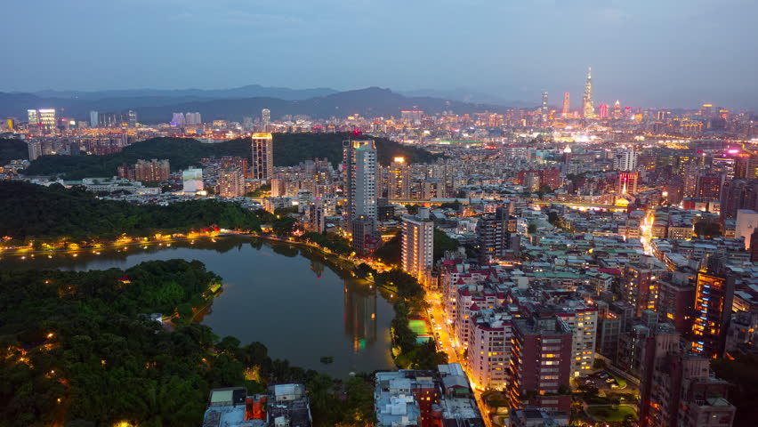Night skyline of downtown Taipei, the vibrant capital city of Taiwan, with 101 Tower standing out amid the skyscrapers in XinYi District and residential buildings next to Bihu Park in Neihu District Royalty-Free Stock Footage #1106823157