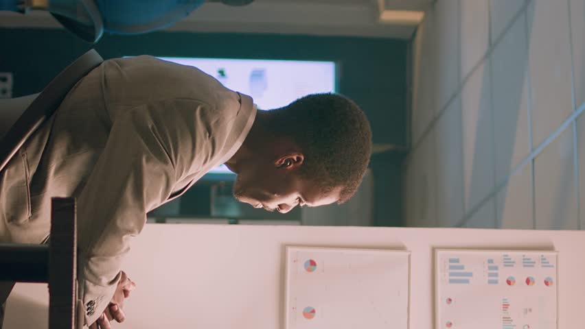 Vertical video Seasoned company manager working overnight in office, holding team teleconference meeting with employees. Management executive chatting with staff members during online videocall