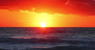 Tropical sunrise with dramatic clouds and sun rays over ocean waves and caribbean sea, seascape horizon 4K video