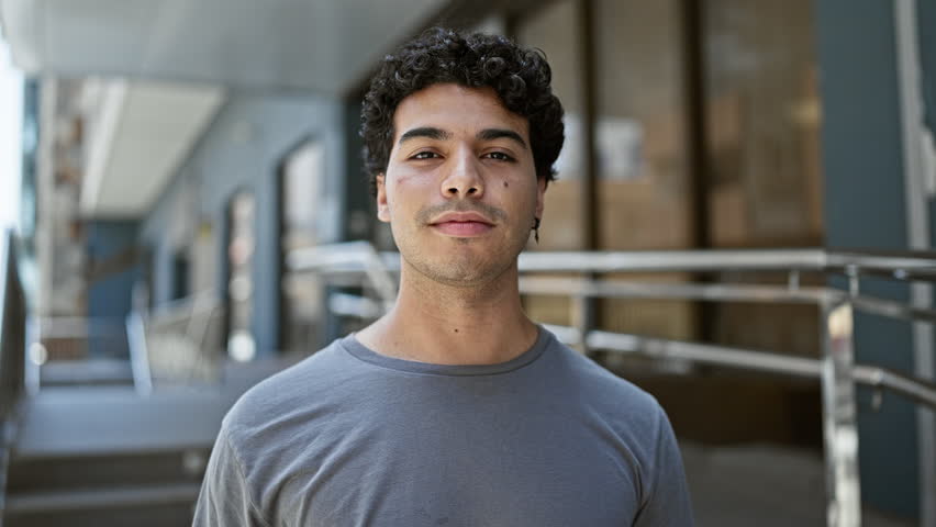 Young latin man smiling confident holding canadian passport at street