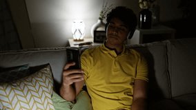 Young latin man having video call sitting on sofa at home