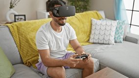 Young arab man playing video game using virtual reality glasses and joystick at home