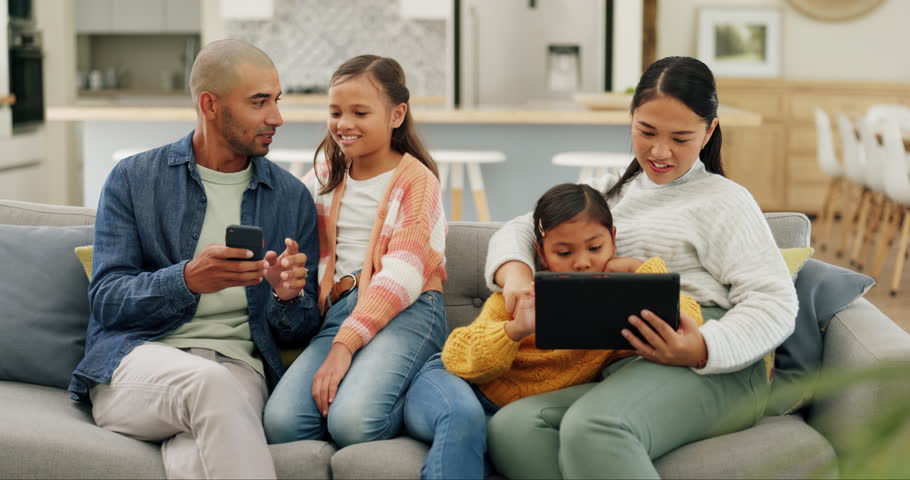 Parents networking with their girl kids on a technology on a sofa in the living room at home. Bonding, love and young mother and father browsing on a cellphone and digital tablet with their children.