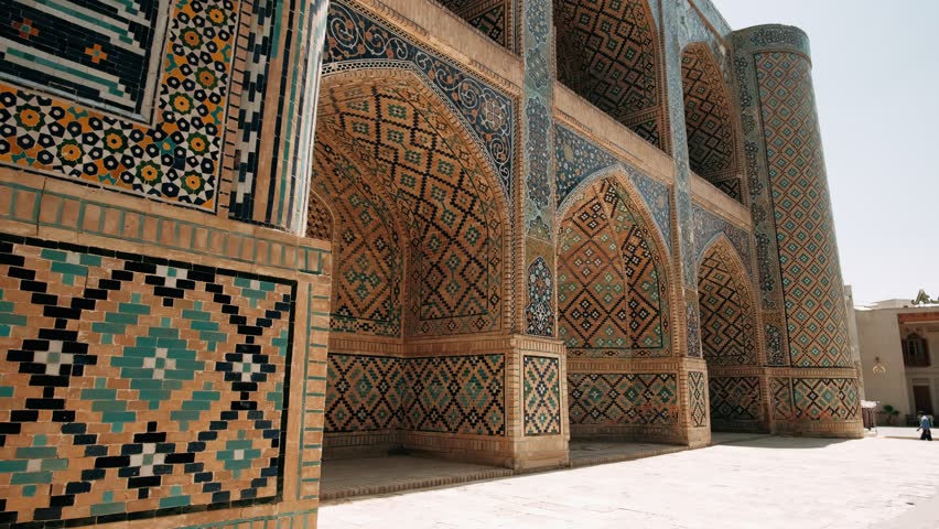 Medieval oriental architecture, Beautiful Patterned Wall. Amazing facade covered by glazed mosaic tiles. Bukhara is a popular tourist attraction of Central Asia. Uzbekistan. Royalty-Free Stock Footage #1106843607