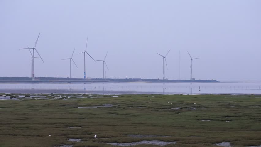 Shooting scenery and wind turbines in the distance in Gaomei Wetland in the early morning