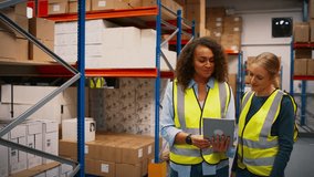 Team leader with digital tablet in busy distribution warehouse training female intern- shot in slow motion - Powered by Shutterstock - Get 15% off with code: PIKWIZARD15