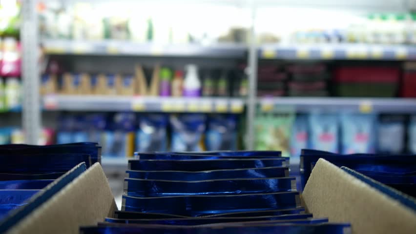 Close-up of many packages with jelly cat or dog food in a store and a male buyer takes two Royalty-Free Stock Footage #1106861845