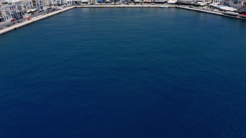 Aerial: Slow reveal shot of picturesque Emoupoli town of Syros island ,Cyclades, Greece