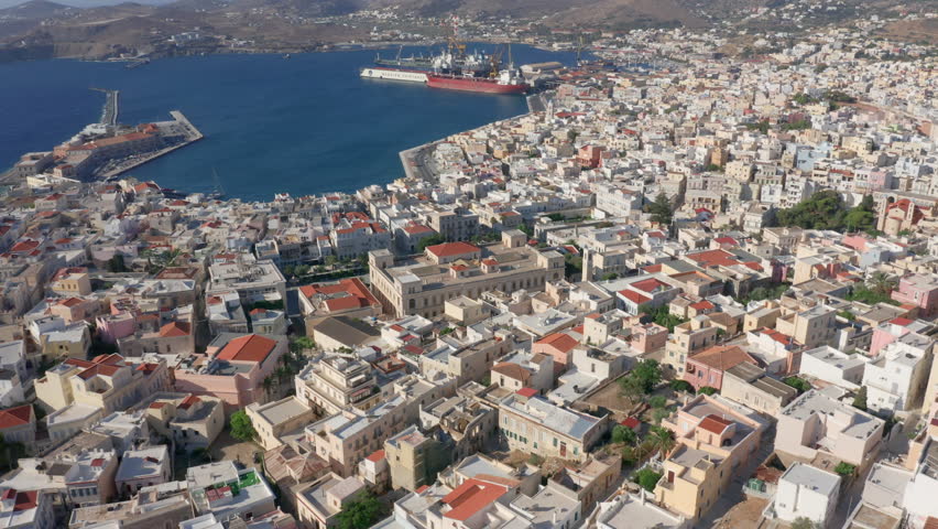 Slow panoramic drone shot of Miaouli square in Ermoupoli city of Syros island, Greece during sunrise