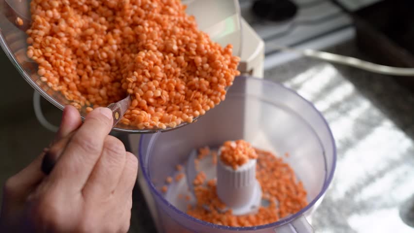 Hand Pouring Turkish Lentil Grains Over A Food Processor Machine. High Angle Shot Royalty-Free Stock Footage #1106863457