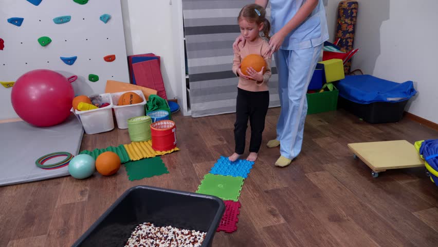 Kid on Sensory Mat Massage during sensory integration session. child girl in rehabilitation centre with physiotherapist doing orthopedic correction.  Royalty-Free Stock Footage #1106866583
