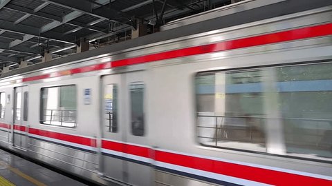 Jakarta, Indonesia, July 19th, 2023: The Commuter train speeds along the tracks before coming to a halt, then departs from Sudirman station in Jakarta Redaksjonell arkivvideo