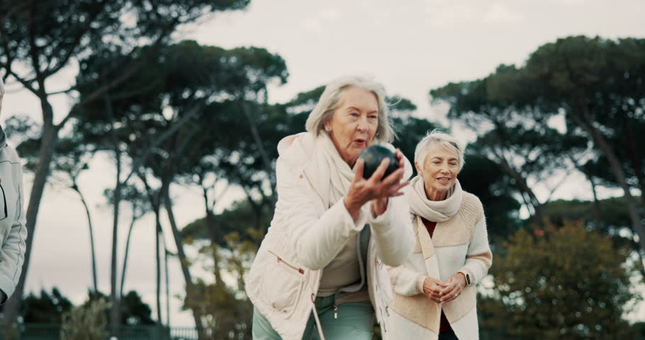 Senior women, celebration and park for bowling, sports and happy for fitness, goal and applause in nature. Teamwork, elderly lady friends and metal ball for games, contest or win together on grass Royalty-Free Stock Footage #1106870937