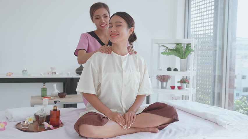Thai massage for young woman by skilled masseuse. Tranquil spa massage of relaxation and rejuvenation for young woman and customer. Blissful massage experience for young woman and customer. Royalty-Free Stock Footage #1106872461