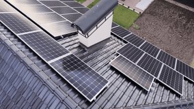 Aerial drone view of solar panel modules for generating electricity through photovoltaic effect on house rooftop. Video footage of home with ecological solar power system on roof.