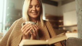Portrait of charming blond mature woman under the blanket with cup of hot tea or coffee and reading book literature at home Calm relaxed female enjoying weekend leisure time alone indoors - Powered by Shutterstock - Get 15% off with code: PIKWIZARD15
