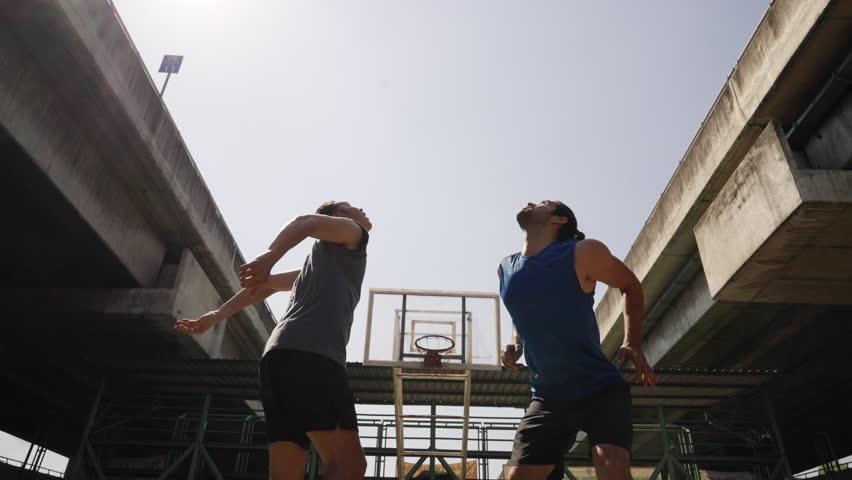 Two strong basketball player playing streetball match shooting and defense basketball on outdoor street court in sunny day. Healthy man athlete do sport training fitness workout exercise in the city. - Powered by Shutterstock - Get 15% off with code: PIKWIZARD15