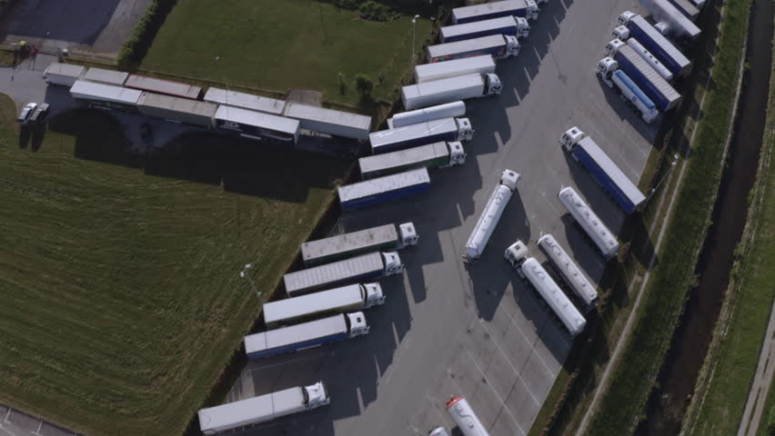 Tank truck riding on road to distribution deport aerial view. Liquid tanker driving on sunlit warehouse shipment terminal parking area Royalty-Free Stock Footage #1106882473