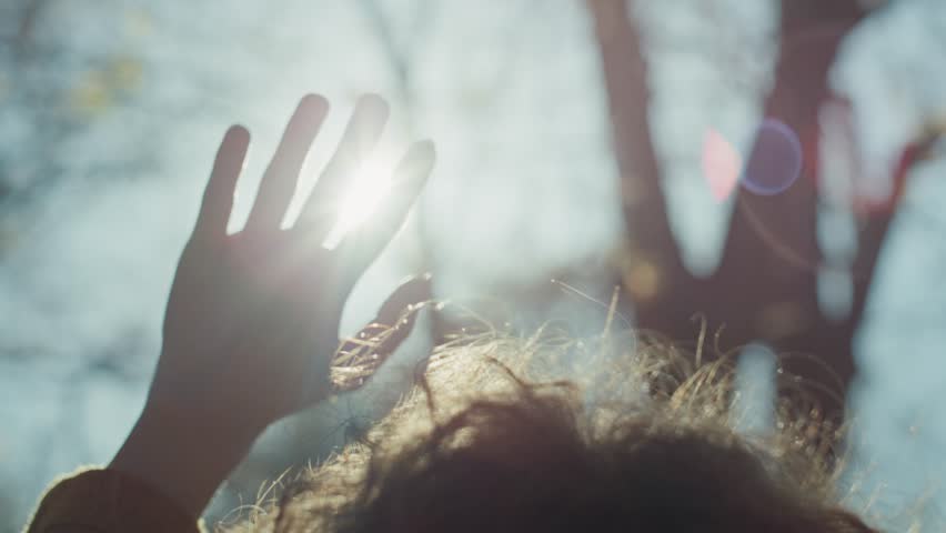 Close up of woman with hand raised looking at the sun. Shot with RED helium camera in 8K.  Royalty-Free Stock Footage #1106883357