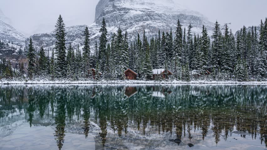 Time lapse beautiful scenery of Lake Ohara with wooden cottage in snowy pine forest and lake reflection on winter at Yoho national park, British Columbia, Canada