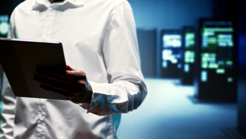 IT developer in server farm housing data management rigs, storage devices and networking devices providing vast amounts of computing resources. Admin doing infrastructure maintenance