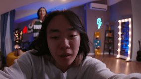 Two Asian Gen Z friends, K-pop dancers, are making trending videos, face close-up. Life in social media and recreation applications, Asian content creators in funny cringe mood recording video content