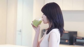 Young woman drinking a green smoothie