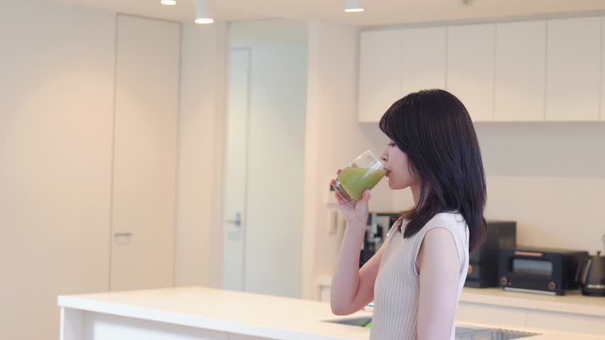 Young woman drinking a green smoothie Royalty-Free Stock Footage #1106889793