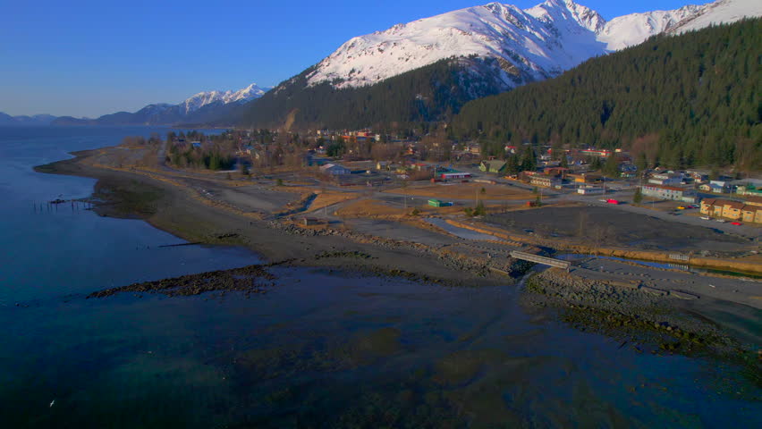 High aerial view of downtown Seward Alaska with mountains at sunrise. 4k drone.