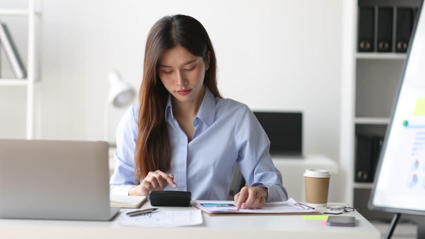 Businesswoman reading documents while working on accounting paperwork and analyzing financial budgets in the office. Royalty-Free Stock Footage #1106894541