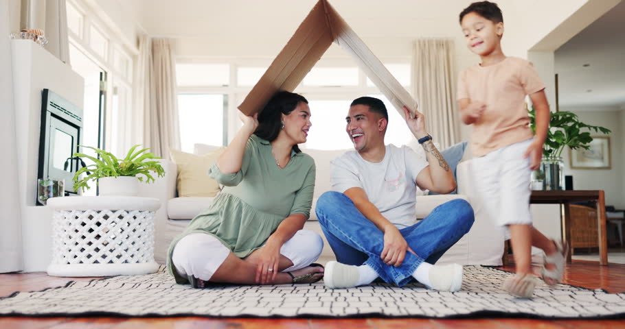 Roof, house and smile with family in living room for property, investment or support. Safety, mortgage and real estate with portrait of parents and child with cardboard for home insurance or security