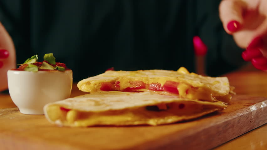 Close up of cheese quesadilla, Eating Traditional Mexican food, tex mex cuisine. Hands taking cooked quesadilla with vegan pork beef meat and vegetables, 