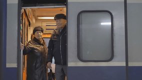 Elderly seniors couple old man and woman at the train door travel departure from railway station waving hands bye - Powered by Shutterstock - Get 15% off with code: PIKWIZARD15