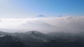 Aerial view of countryside on the mountain slope with view sea of clouds and mountain range - Rural landscape of Indonesia