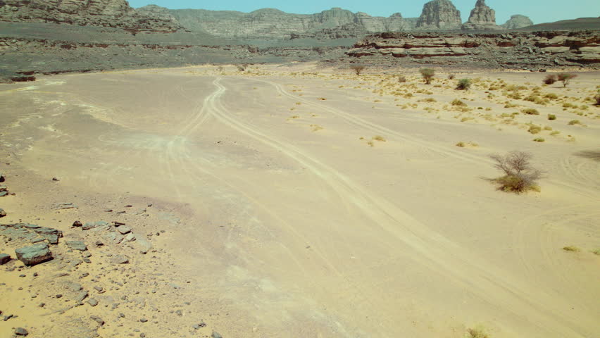 Man Standing On The Edge Of A Cliff In Djanet Desert In Algeria - aerial pullback