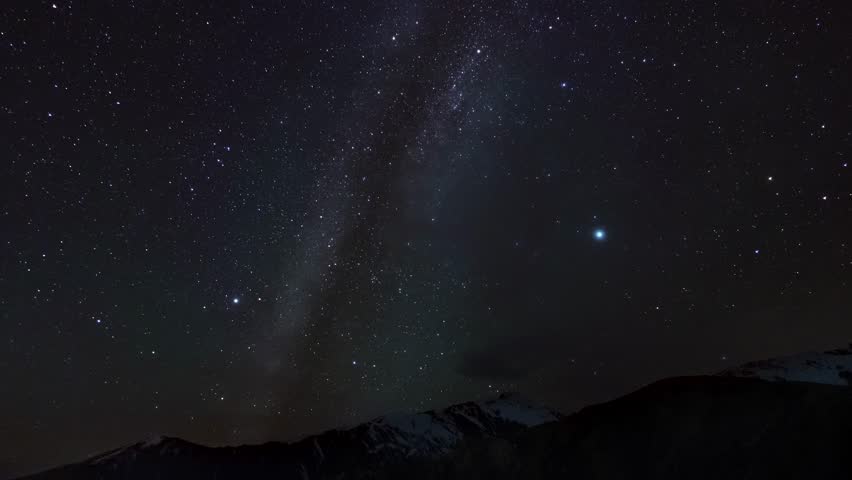 Majestic view of night sky over mountain range filmed from below in timelapse. Scenery of shining stars moving and rotating above cliffs. Cosmos and astronomy. Enjoying milky way view. Universe theme.