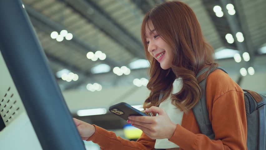 Happy asian woman using self check-in machine at the airport terminal getting the boarding pass, Technology in airport, Tourist journey trip concept Royalty-Free Stock Footage #1106916745