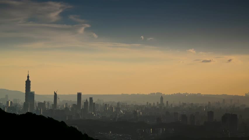Blue sky with white dynamic clouds over the city at dusk at sunset. View of the urban landscape from Dajianshan Mountain, New Taipei City, Taiwan
