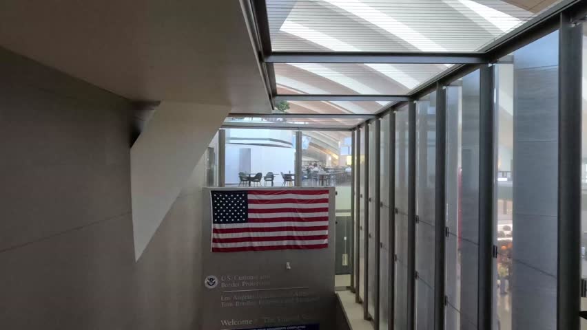 Los Angeles, California, USA - July 26 2023: The American flag and sign for US Customs and Border Protection at Los Angeles International Airport (LAX).