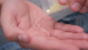 Pills falling from meds bottle in man's hand. Closeup