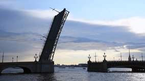 Side view from embankment of open bascule bridge above Neva river at twilight in Saint Petersburg city. Clear blue sky. European cityscape. Real time video. Travel in Russia theme.
