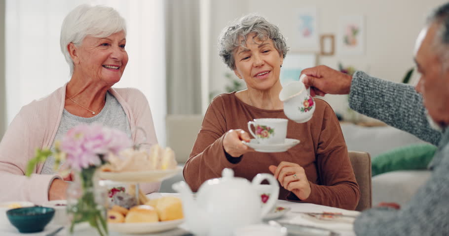 Senior man, women and pouring milk at tea party, helping hand and conversation with care, drink and retirement. Elderly group, chat and relax with reunion, coffee or brunch with social in living room