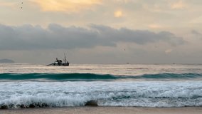 the boat of some fishermen on the water seen from the beach in Copacabana, Rio de Janeiro. 4k video.