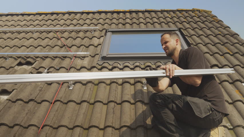 MS PAN Technicians installing solar panel racks on roof | Shutterstock HD Video #1106933139