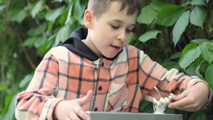 boy opts for fountain water over bottled, a potent symbol of environmental care. His choice reduces plastic waste, embodying the sustainable actions needed for a healthier planet