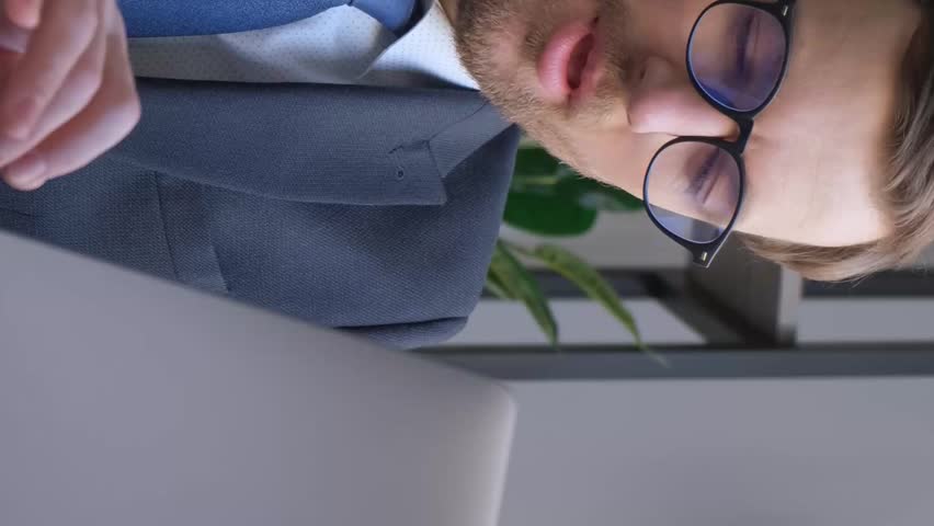 Tired manager yawns at work while using laptop, businessman looks exhausted and needs energy | Shutterstock HD Video #1106935893