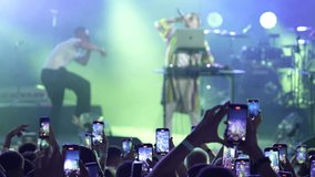 At the concert, the DJ plays music, fans hold smartphones in front of the stage, broadcast live, record videos and take pictures.