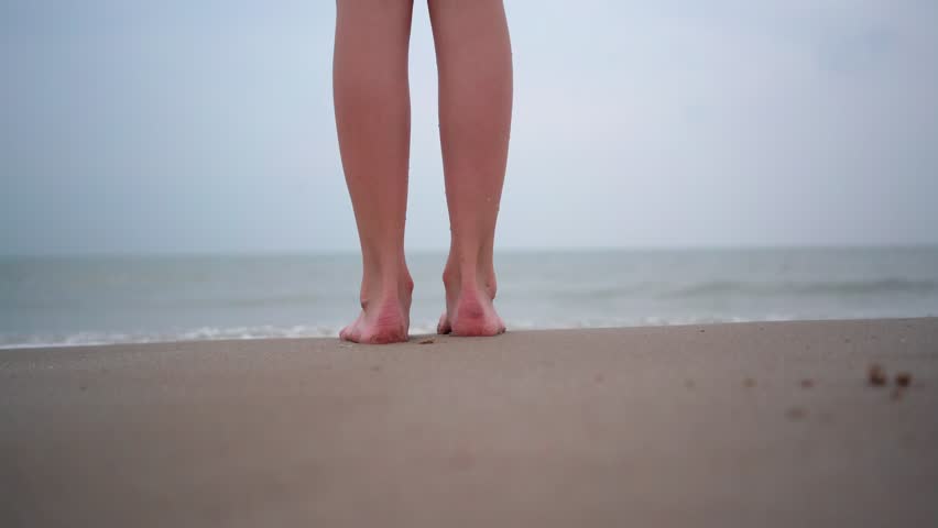 Close up of person bare feet walking at tropical beach. People playing barefoot at tropical beach. Having fun jumping in sea water on warm sunny day on seashore. Summer travel and vacation concept. | Shutterstock HD Video #1106936249