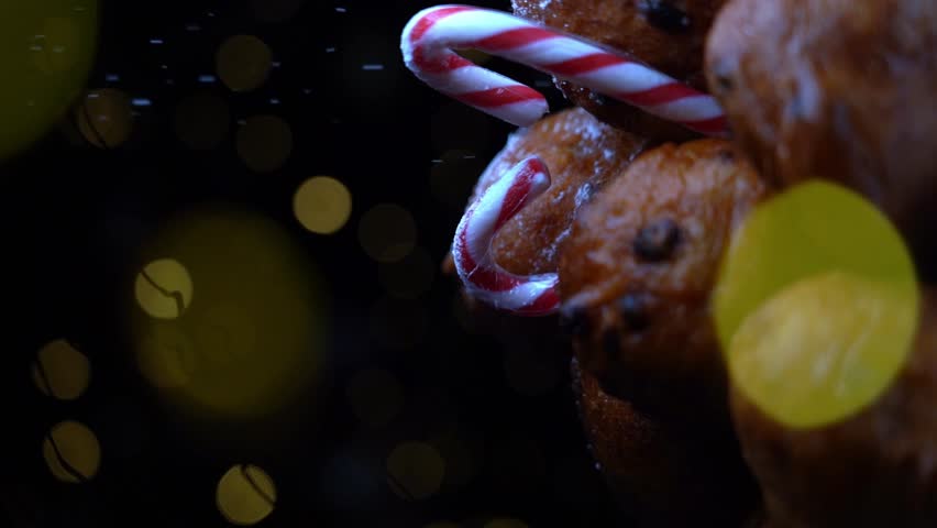 'Oliebollen', traditional Dutch pastry for New Year's Eve with sparkles. oil dumpling or fritter with sugar powder on top. Christmas tree lights bokeh on background. Typical food.  | Shutterstock HD Video #1106936271